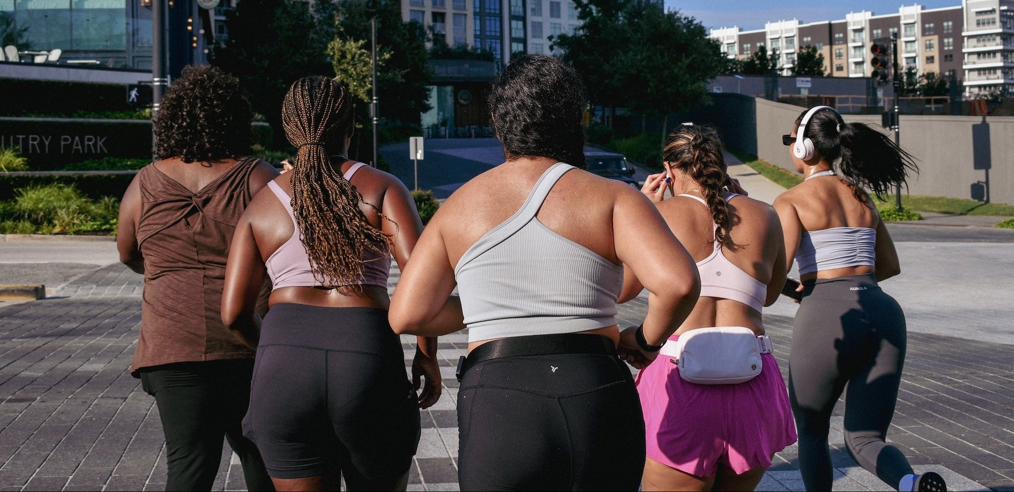 Group of women walking outdoors with a cityscape in the background
